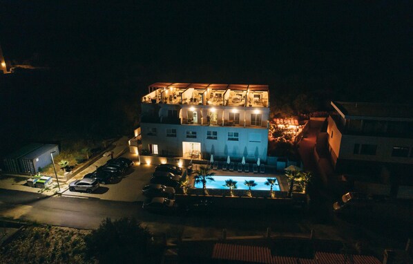 A multi-story hotel with outdoor seating and a pool.
