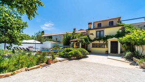 A courtyard with a pool, a small garden, and a building with a tiled roof. - Pet friendly home in Veliki Vareski (Veliki Vareski)