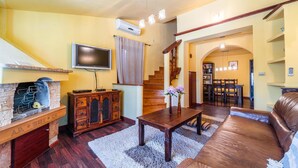 A living room with a fireplace, a television, a staircase, and a dining area. - Pet friendly home in Veliki Vareski (Veliki Vareski)
