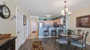 Enjoy meals in the well-appointed kitchen and dining area, featuring a central island and wooden table.