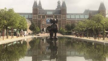 Un bâtiment historique doté d’une grande tour centrale et d’une statue en premier plan.