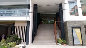 Una entrada de hotel con una escalera que conduce a un edificio moderno.
