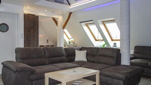 Una sala de estar moderna con un sofá modular, una mesa de centro y tragaluces.