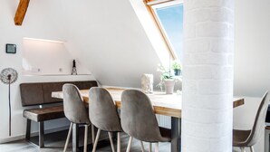 Un comedor moderno con una mesa de madera, sillas tapizadas de gris y un banco.
