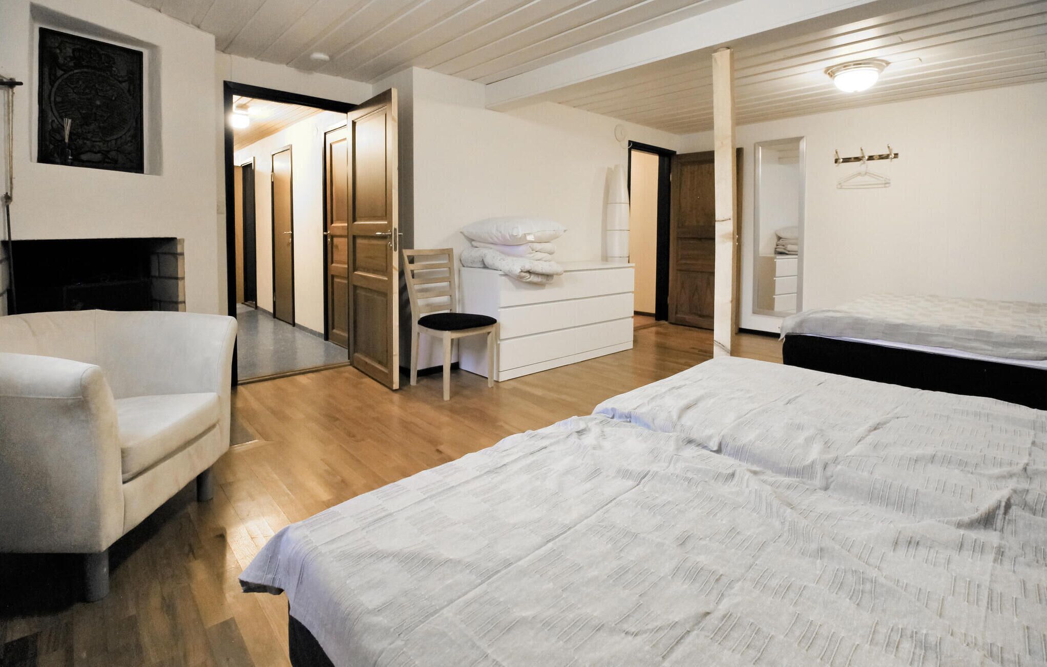 A hotel room with a bed, a chair, a small desk, and a wardrobe.