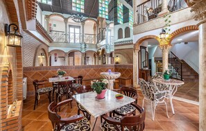 A spacious dining area with high ceilings, ornate columns, and a central fountain. - Nice home in Galera with WiFi (Galera)