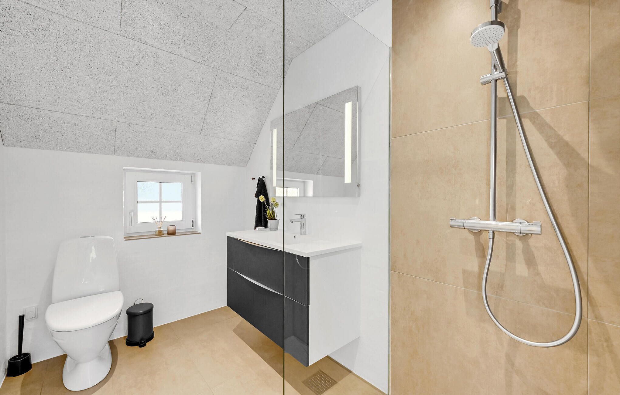 Une salle de bain moderne équipée de toilettes, d’un lavabo et d’une douche.