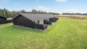 Een modern gebouw met een schuin dak, grote ramen en een verzorgd gazon.