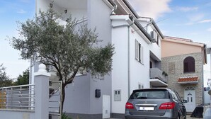 A modern building with a grey facade, a tree in front, and a parked car. - 2 bedroom lovely apartment in Zadar (Zadar)
