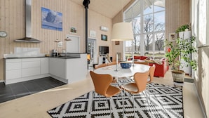 A modern kitchen with white cabinets, a black countertop, and a large window.