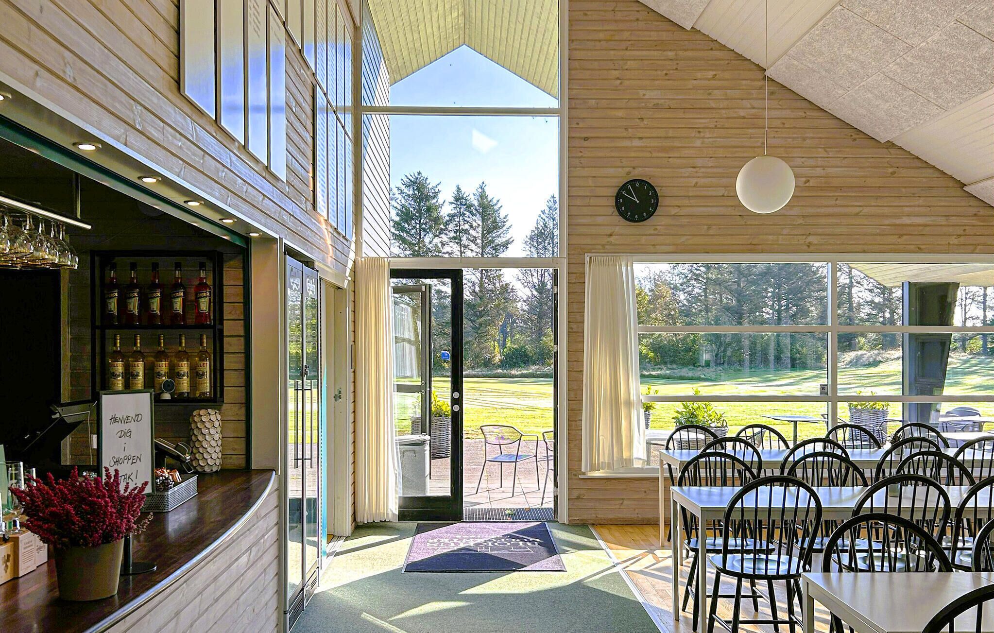 A restaurant with a bar area, outdoor seating, and a view of a golf course.