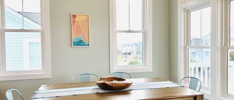 A dining area with a wooden table, blue chairs, and a bowl centerpiece.