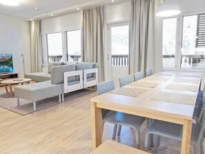 A modern conference room with a long table, chairs, a sofa, and a television. - Rukakylän helmi by Interhome (Kuusamo)
