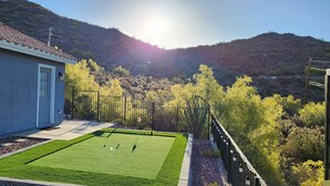 A residential property with a well-maintained lawn, a house with a tiled roof, and a view of a hilly landscape. - Desert Valley Stay - Mountain Views (Phoenix)