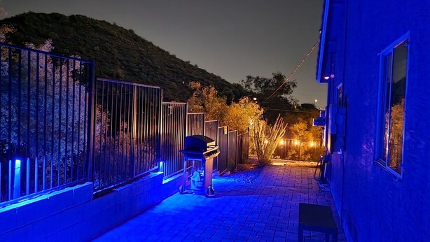 A pathway leading to a building with a metal fence and a barbecue grill. - Desert Valley Stay - Mountain Views (Phoenix)