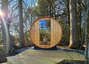 Eine Holzhütte mit Glastür, umgeben von Bäumen.