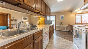 A kitchen with wooden cabinets, a stainless steel sink, and a dishwasher. - Vacation UniquEly home in town, with patio (Ely)