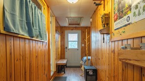 A narrow hallway with wooden walls, a bench, a door, and a window. - Vacation UniquEly home in town, with patio (Ely)