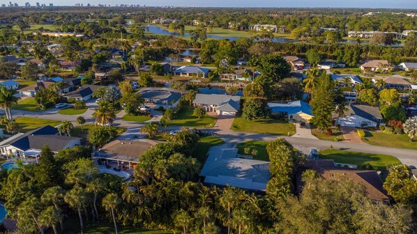 Vista aérea de una zona residencial con casas, calles y un campo de golf.