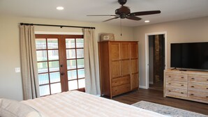 A bedroom with a bed, wooden wardrobe, television, and a ceiling fan. - Relaxing Mountain View Retreat with Pool & Spa! (Bonita)