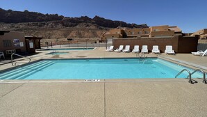 A swimming pool with white lounge chairs, a no diving sign, and a mountainous backdrop. - New!  Beautiful, secluded views 10 minutes from Downtown Moab!  (Moab)