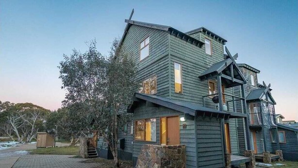A multi-story building with a steep roof, large windows, and a stone foundation. - Snow Dayz - Dinner Plain (Dinner Plain)