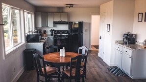 A modern kitchen with a central island, white cabinets, and a stainless steel refrigerator. - Beautiful 2 bedroom home with amazing views (Gaston)