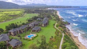 Un complejo turístico frente al mar con varias construcciones y piscina.