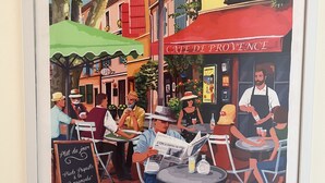 Ein Café mit Außenbereich, einem Schild mit der Aufschrift 'Café de Provence' und einer Kreidetafel-Speisekarte.
