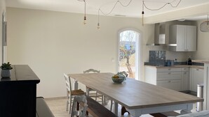 Eine moderne Küche mit weißen Schränken, einem Holztisch und einer eingebauten Sitzbank.