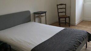 A bedroom with a bed, a chair, a small table, and a window. - 10 minutes from Penly Ideal for seasonal workers, athletes and walkers (bailly en rivière)