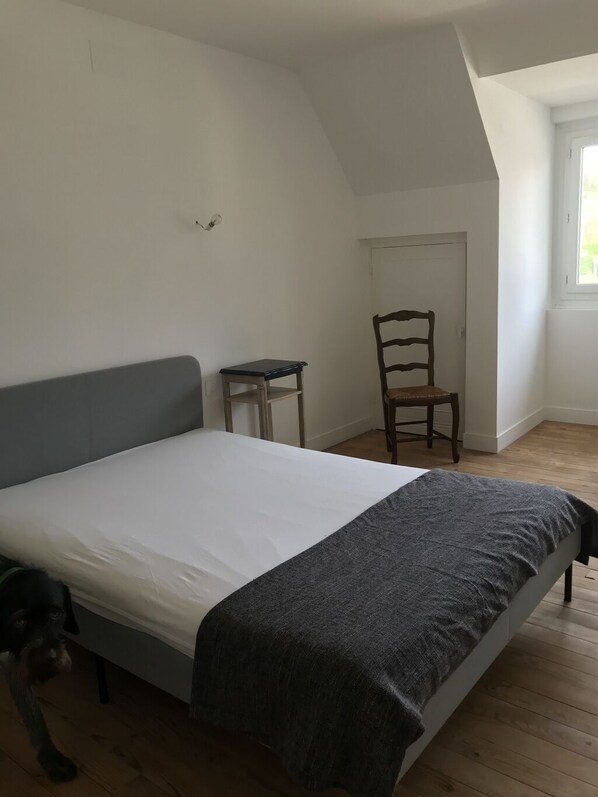 A bedroom with a bed, a chair, a small table, and a window. - 10 minutes from Penly Ideal for seasonal workers, athletes and walkers (bailly en rivière)