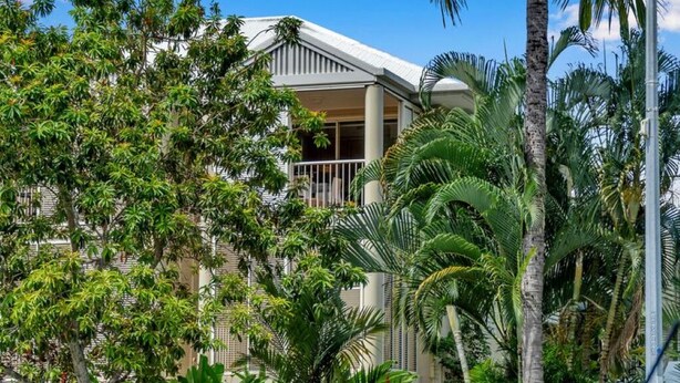 A hotel with a white facade, a balcony, and lush tropical vegetation. - Top Spot on Macrossan, Port Douglas 100m to Beach (Port Douglas)
