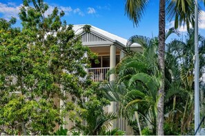A hotel with a white facade, a balcony, and lush tropical vegetation. - Top Spot on Macrossan, Port Douglas 100m to Beach (Port Douglas)