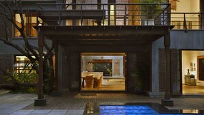 A modern house with a pool, a covered patio, and a dining area visible through the open door. - amã Stays & Trails The Mango House, Alibag (Alibag)