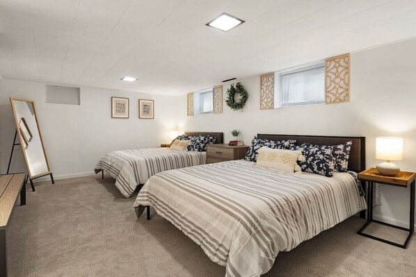 Une chambre avec deux lits, un bureau et une commode.