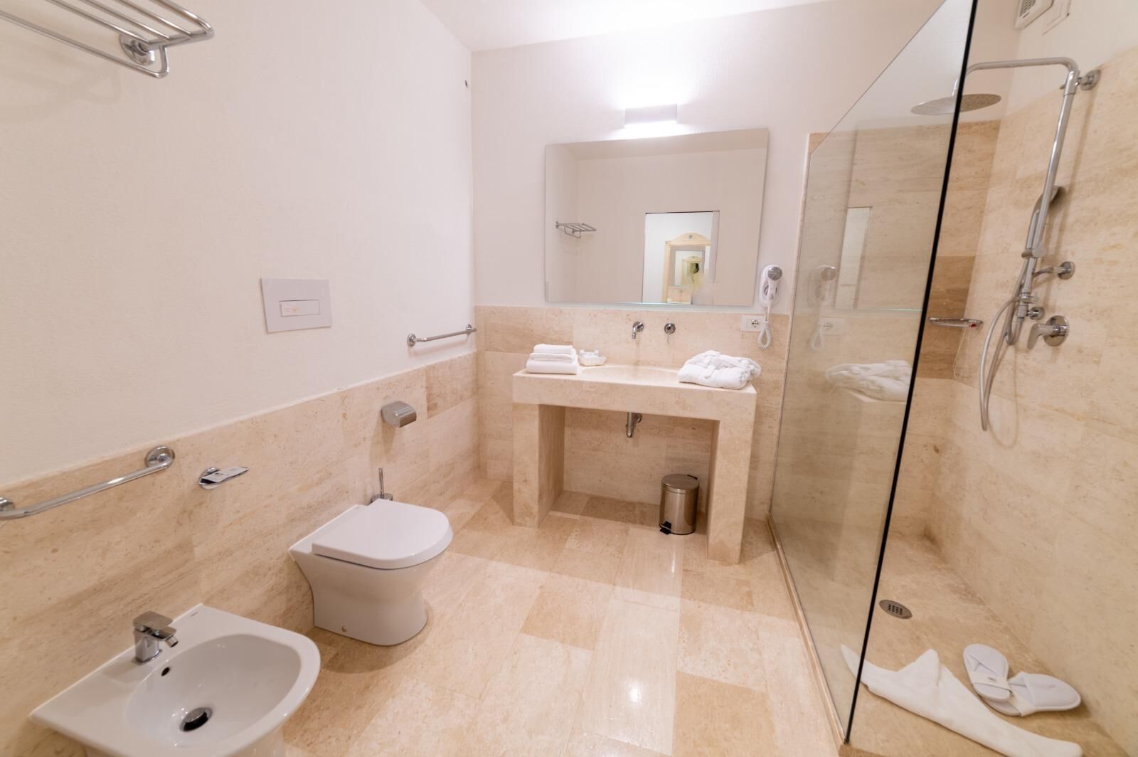A modern bathroom with a glass-enclosed shower, a sink, and a toilet.