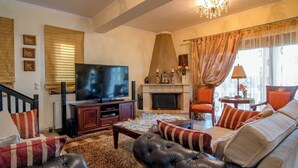 A living room with a fireplace, a television, and a sofa. - Villa Napolia - Luxury Villa With Amazing Sea View (Zakynthos)