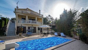 A two-story building with a swimming pool, outdoor furniture, and a covered seating area. - Villa Napolia - Luxury Villa With Amazing Sea View (Zakynthos)