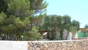 Un mur de pierres avec un autre mur de pierres et une pergola en bois.