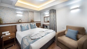 A hotel room with a bed, bedside table, nightstand, and a sofa. - Lika Hotel - Eco Double Room (Istanbul)