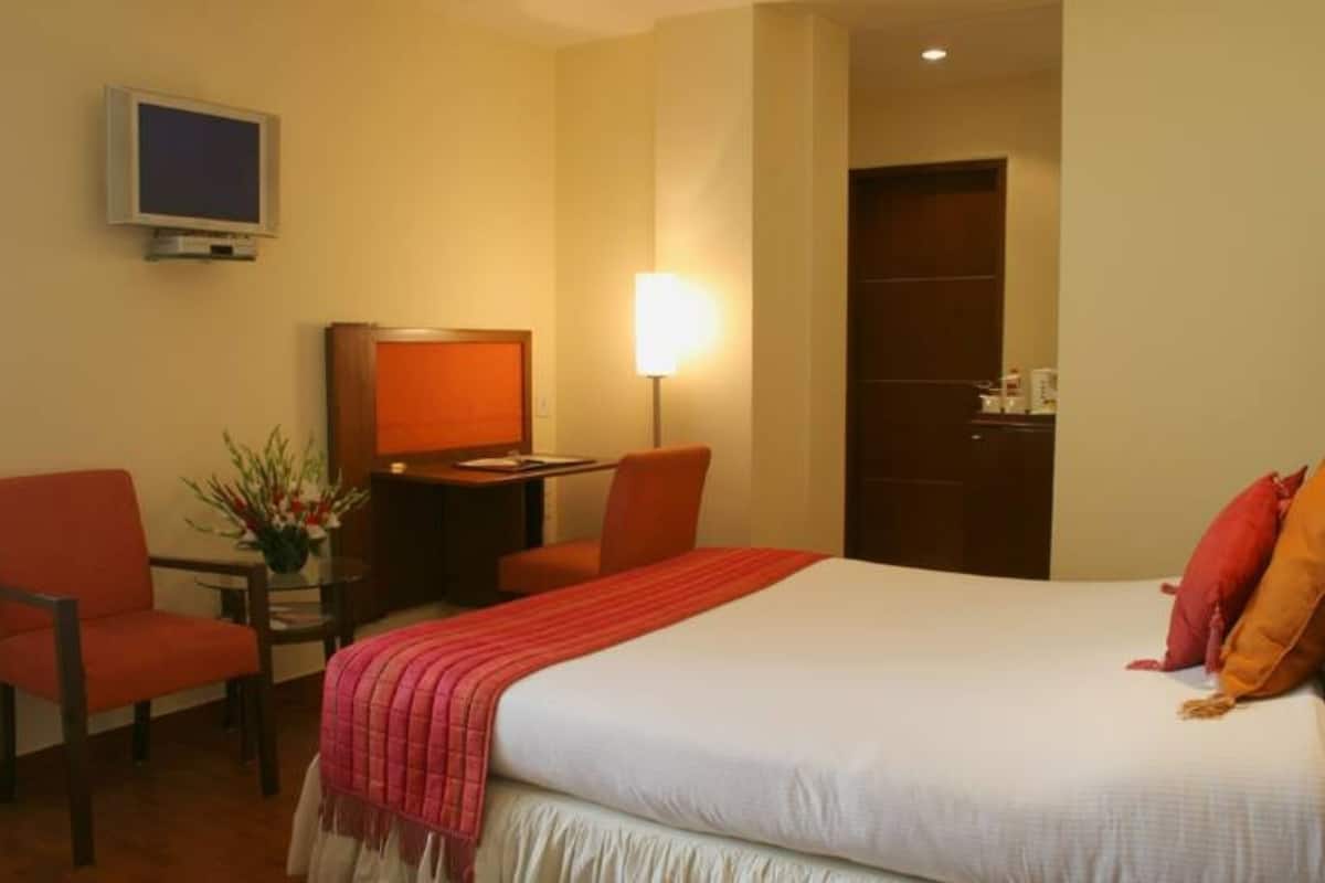 Habitación clásica | Escritorio, cortinas blackout y tabla de planchar con plancha