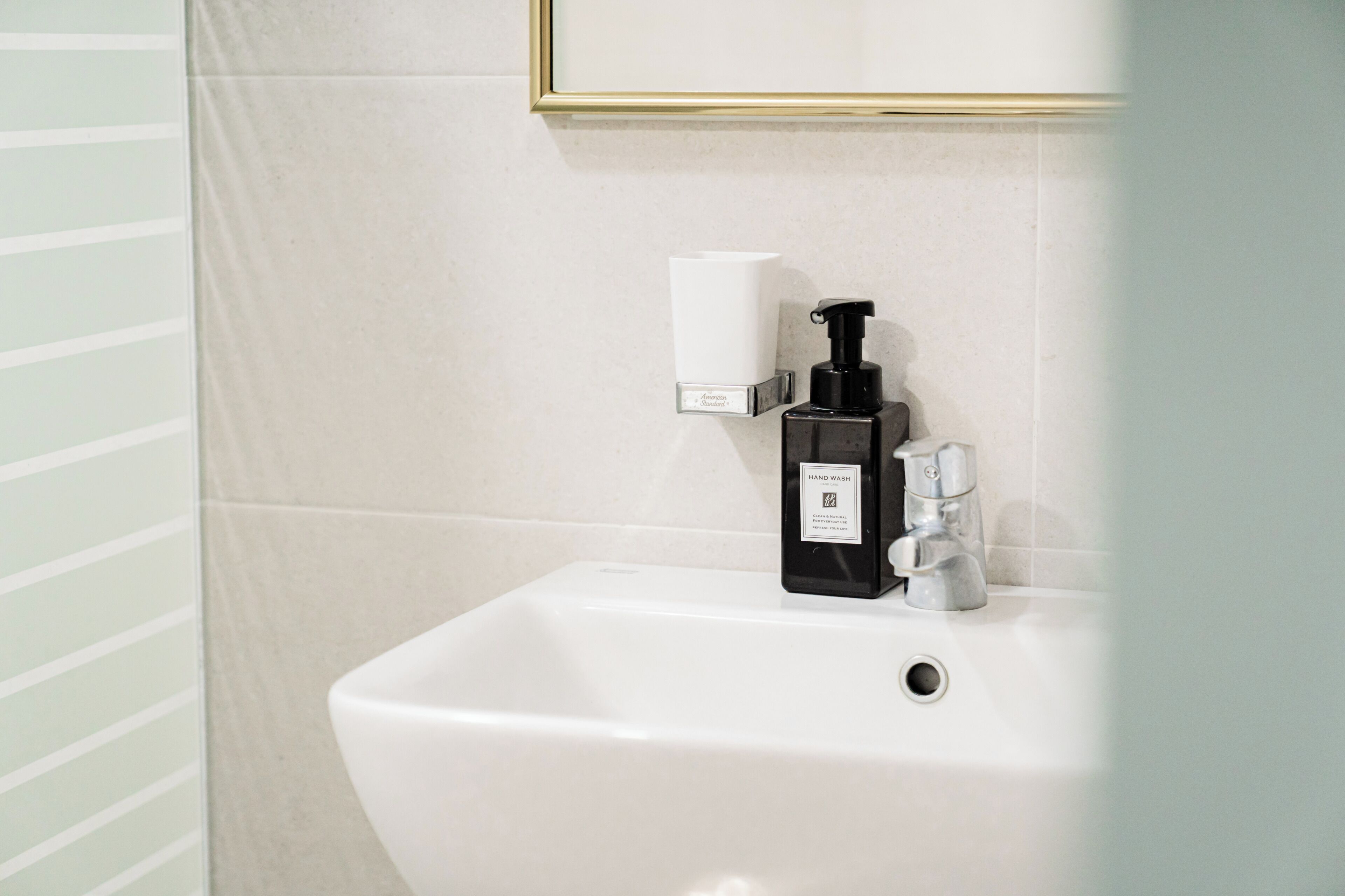 Ein Waschbecken mit Seifenspender und Papierhandtuchhalter.