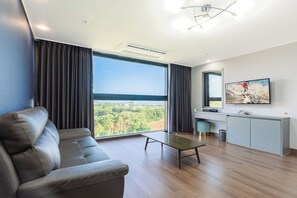 Een moderne woonkamer met een bank, een salontafel, een televisie en uitzicht op het buitengebied.