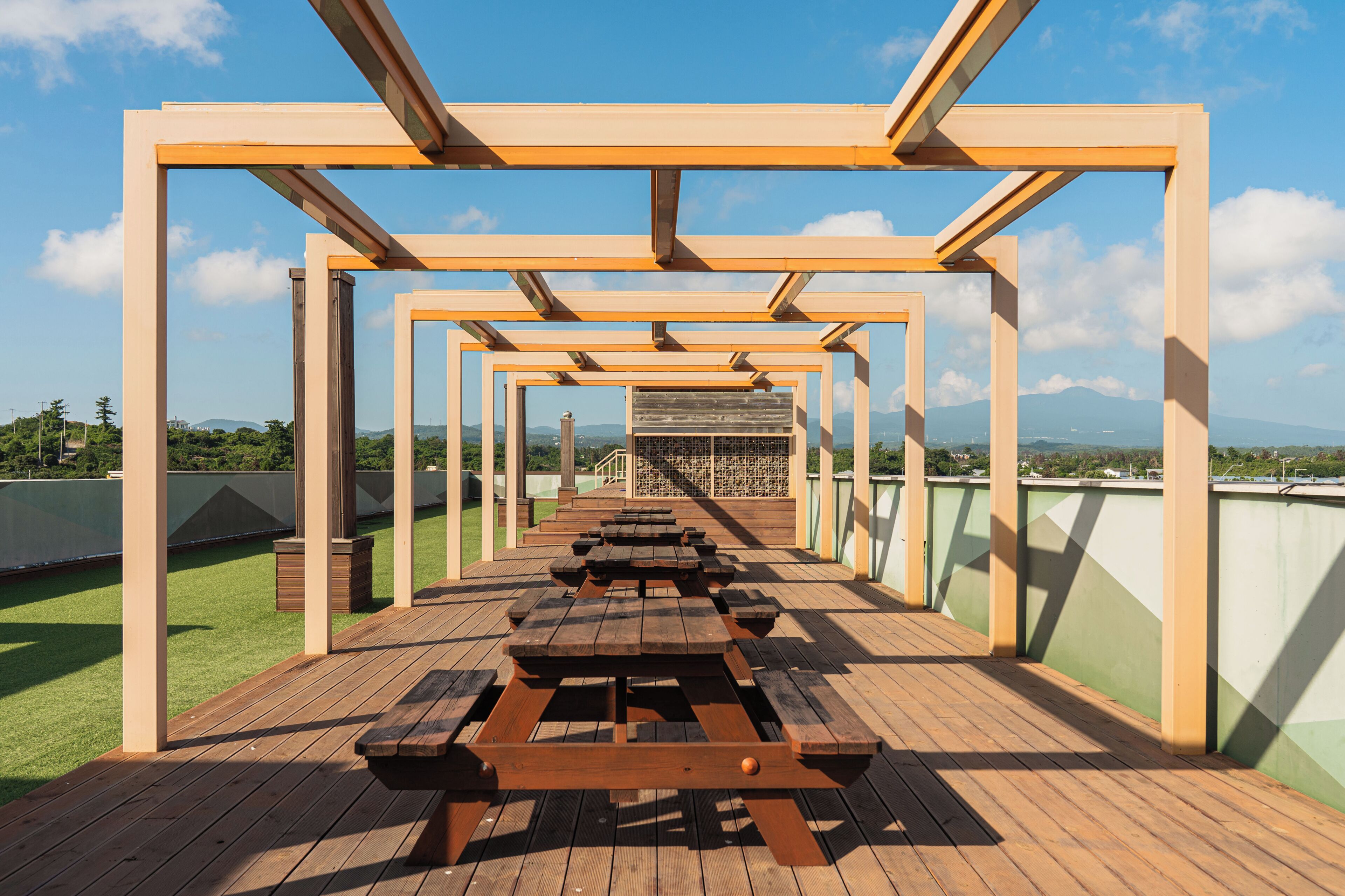 An outdoor deck with wooden benches and a view of the cityscape.