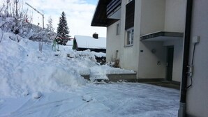 A snow-covered driveway leading to a building with a garage. - Elfe Apartments Studio for 2 Adults, Balcony With Lake and Mountain View (Emmetten)