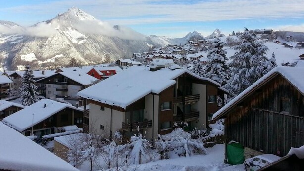 A snow-covered mountain town with buildings and a prominent peak in the background. - Elfe Apartments Studio for 2 Adults, Balcony With Lake and Mountain View (Emmetten)