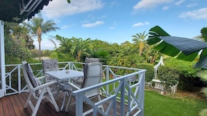 A wooden deck with a white railing, a table, and two chairs. - Room in Apartment - The Garden Apartment - Roosboom Luxury Facilities in Somerset West, 2 Guests (Cape Town)