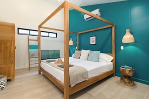 A four-poster bed with a wooden frame, a teal accent wall, and a ceiling fan.