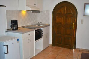 Compact kitchen with oven, coffee maker, and sink, perfect for travelers seeking convenience and efficiency.